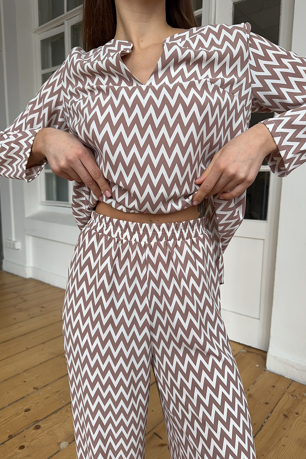 Mocha-colored trouser suit with slits and a shaped neckline