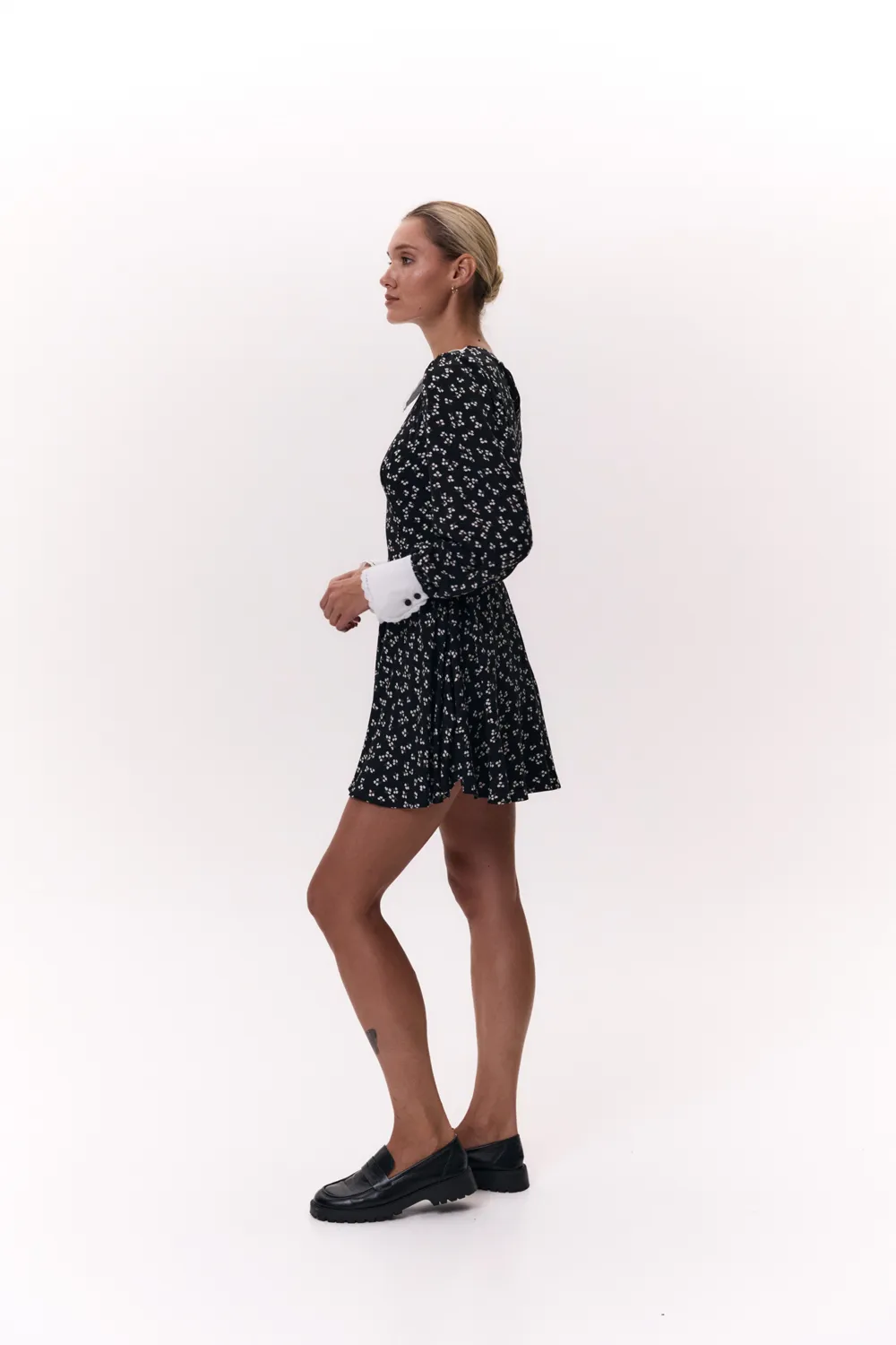 Black semi-fitted dress with a half-sun skirt and puffy cuffed sleeves